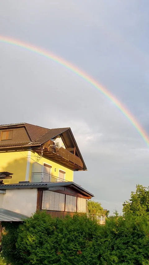 Double Rainbow Over House and Lush Green Backyard Under Soft Evening Sky Stock Footage 331854544