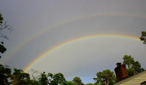 Double rainbow over tree line in Augusta, Georgia Stock Photos