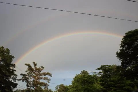 Double rainbow over tree line in Augusta, Georgia Stock Photos