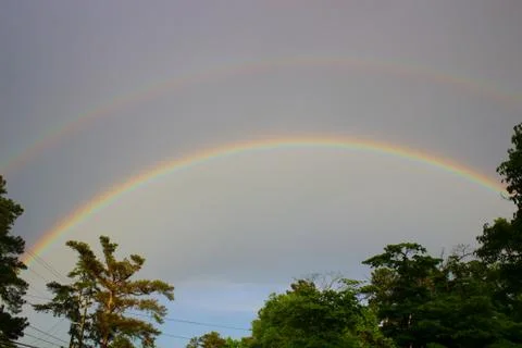 Double rainbow over tree line in Augusta, Georgia Stock Photos