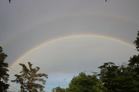 Double rainbow over tree line in Augusta, Georgia Stock Photos
