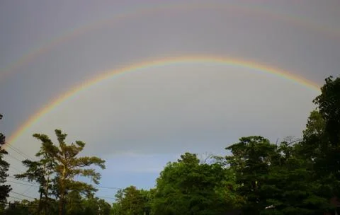 Double rainbow over tree line in Augusta, Georgia Stock Photos