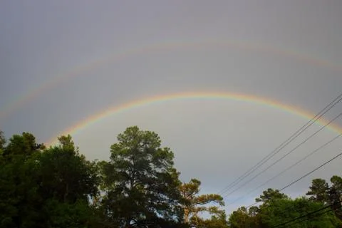 Double rainbow over tree line in Augusta, Georgia Stock Photos