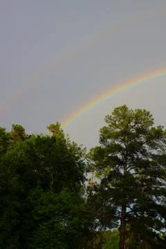 Double rainbow over tree line in Augusta, Georgia Stock Photos