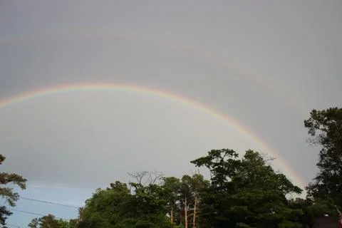 Double rainbow over tree line in Augusta, Georgia Stock Photos