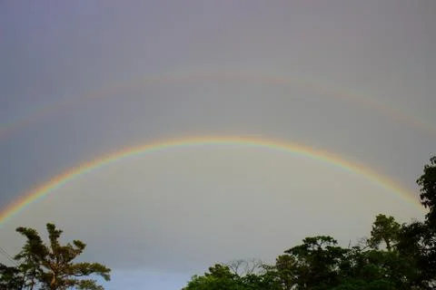 Double rainbow over tree line in Augusta, Georgia Stock Photos