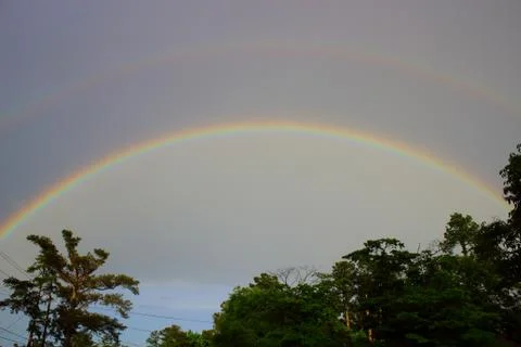 Double rainbow over tree line in Augusta, Georgia Stock Photos