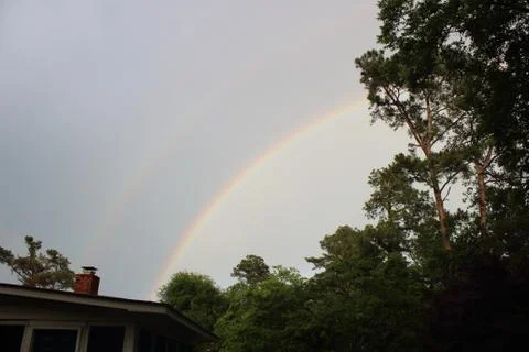 Double rainbow over tree line in Augusta, Georgia Stock Photos