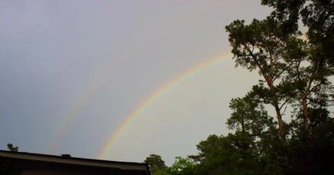 Double rainbow over tree line in Augusta, Georgia Stock Photos