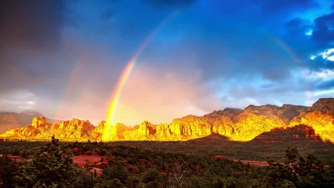 Double rainbow over vivid sunlit red rock mountains after storm clouds. Stock Footage 341138902