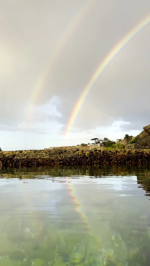 Double rainbow reflected in ocean rock pool. 스톡 동영상 336743744