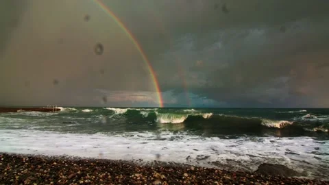 Double rainbow in the sky with clouds after the storm, in the foreground the sea Stock Footage 220633215