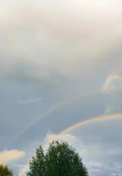 Double rainbow in the sky with clouds Stock Photos