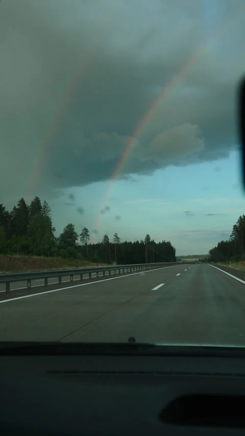 Double rainbow in sky while driving along highway, vertical video. Stock Footage 255043516