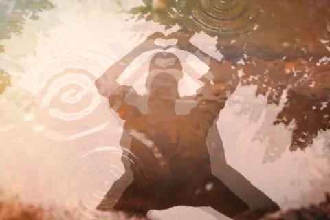 Double reflection in a puddle of a person who shapes a heart with his hands Stock Photos