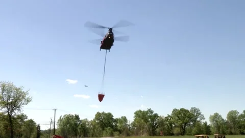 Double Rotor Helicopter Dropping off a Bucket and Landing on a Field Stock Footage 130588067