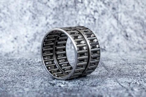 Double row needle roller bearing cage assembly stands on textured concrete .. Stock-Fotos