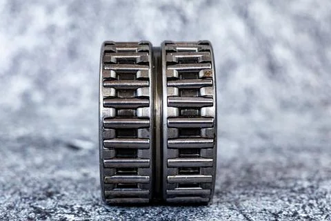 Double row needle roller bearing cage assemblies standing on textured concr.. Stock-Fotos