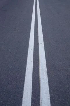 Double Solid White Line Road Marking on Dark Asphalt Surface Vertical View Stock Photos