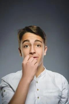Doubt, expression and people concept - boy thinking over gray background Stock Photos