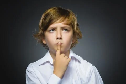 Doubt, expression and people concept - boy thinking over gray background Stock Photos