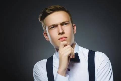 Doubt, expression and people concept - boy thinking over gray background Stock Photos