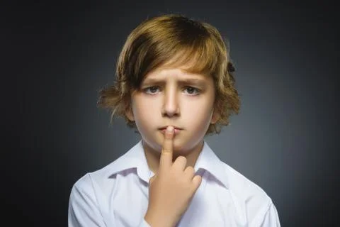 Doubt, expression and people concept - boy thinking over gray background Stock Photos