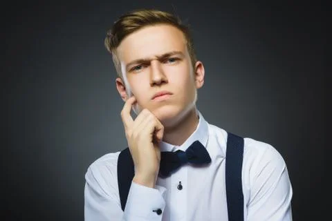 Doubt, expression and people concept - boy thinking over gray background Stock Photos