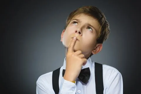 Doubt, expression and people concept - boy thinking over gray background Stock Photos