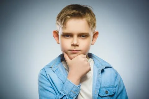 Doubt, expression and people concept - boy thinking over gray background Stock Photos