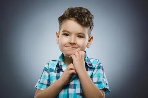Doubt, expression and people concept - boy thinking over gray background Stock Photos