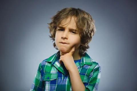 Doubt, expression and people concept - boy thinking over gray background Stock Photos