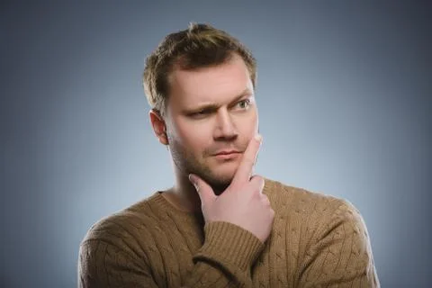 Doubt, expression and people concept - man thinking over gray background Stock Photos