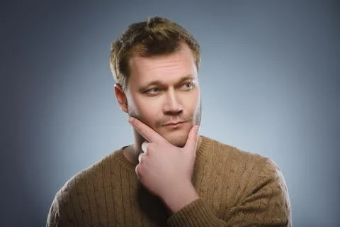 Doubt, expression and people concept - man thinking over gray background Stock Photos