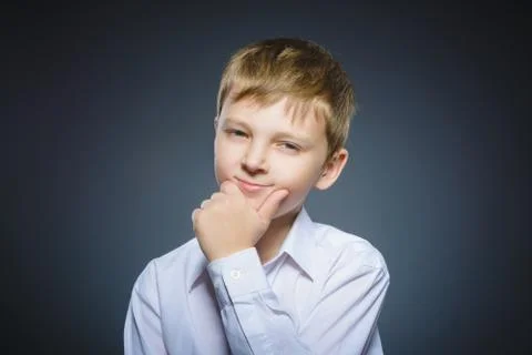 Doubt, expression and people concept - boy thinking over gray background Stock Photos
