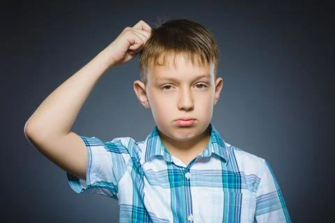 Doubt, expression and people concept - boy thinking over gray background Stock Photos