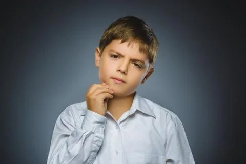 Doubt, expression and people concept - boy thinking over gray background Stock Photos