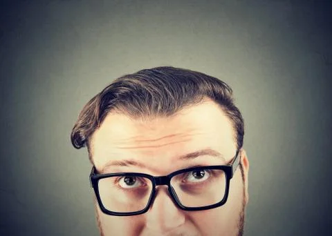 Doubtful man in glasses looking up Stock Photos