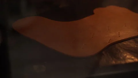 The dough is baked on parchment paper on a baking baking dish in the oven Stock Footage 166528801