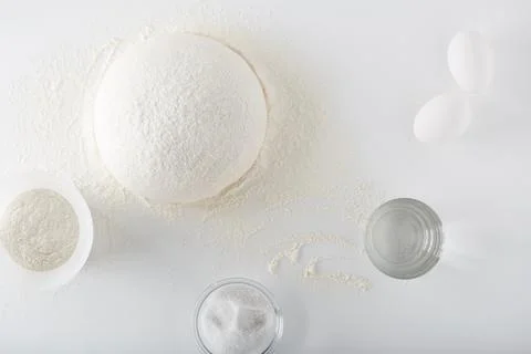 Dough for baking bread and pizza on a white table Stock Photos