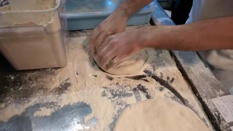 The dough is being kneaded to make pizza. The chef uses his hands to knead the d Stock Footage 171736765