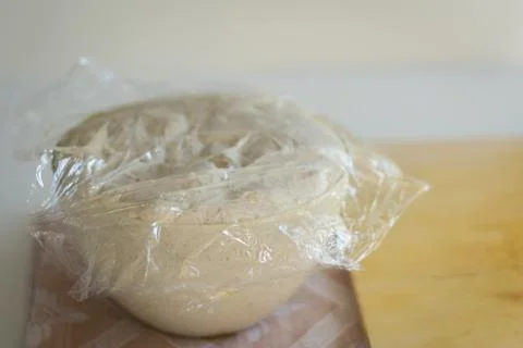 Dough for bread and pizza while rising in the bowl Stock Photos