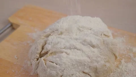 Dough for bread or pizza on a floured surface, with flour splash. Cooking bread 스톡 동영상 168668051