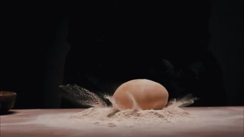 Dough Dropping into the Flour on the table Stock Footage 254939232