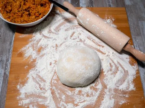 Dough for dumplings, cabbage stuffing on the side and a rolling pin Stock Photos