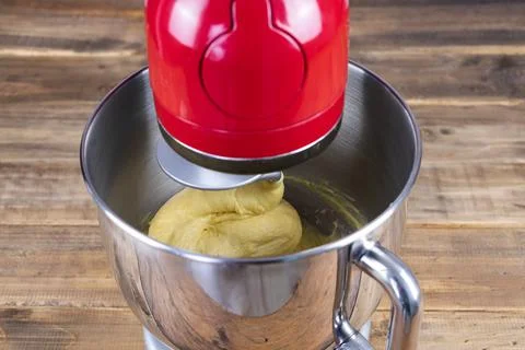 Dough elaboration process with kneading machine. Bakery concept. Stock Photos