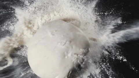The dough is falling into the flour in slow motion. Stock Footage 140247126