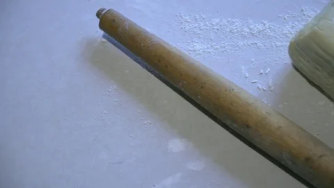 Dough with flour and rolling pin lie on the table Stock Footage 81359188