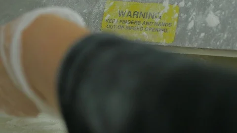 Dough gets pushed flat in machine and woman picks them up Stock-Footage 93374273