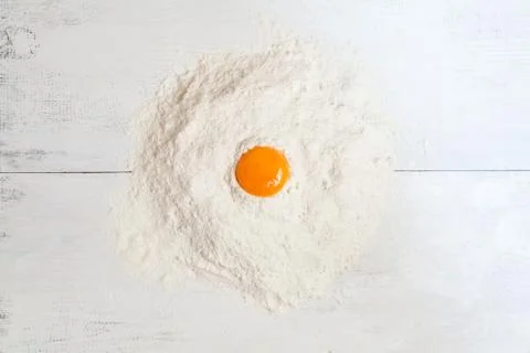 Dough ingredients on white table. Egg yolk and flour Stock Photos